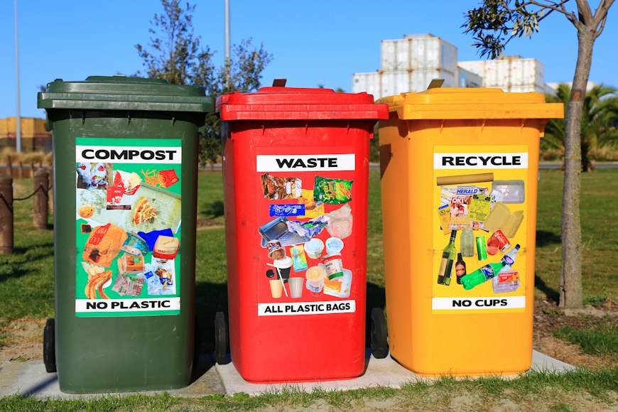 Green, red and yellow waste-separation bins outdoors